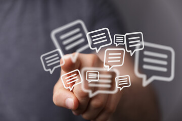 Hand interacting with digital speech bubbles representing conversations, discussions, social networking, and online communication.