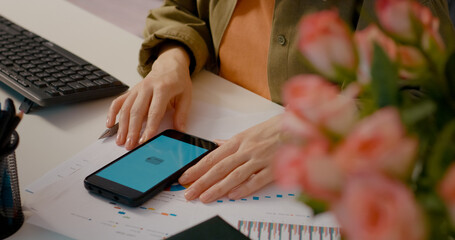 Businesswoman analyzing financial charts and shopping online at her office desk. Concentrating on data and business strategy at modern office workspace