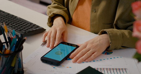 Professional businesswoman analyzing financial charts and shopping online at her office desk. Concentrating on data and business strategy at modern office workspace