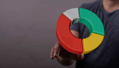 A 3D pie chart graphic being held by a person in a digital interface, representing data analysis, business, and statistics. Suitable for present