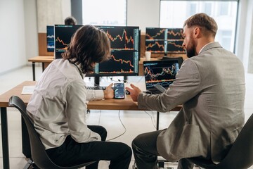 Obraz premium Cooperation and teamwork conception. Two male exchange workers are in the office together