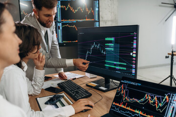 Important data on the screen. Business people are working with stock market exchange in office