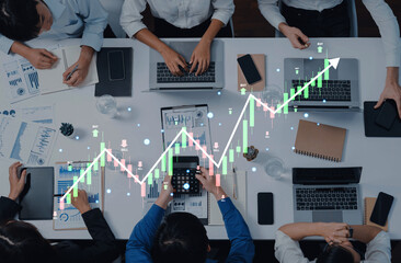 A collaborative business meeting where professionals analyze data and growth charts on laptops, emphasizing teamwork, technology, and financial insights. Trope