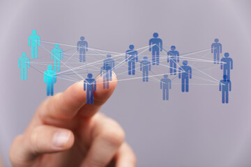 Abstract depiction of digital connectivity and networking. Hand interacting with a network of people symbols, suggesting teamwork and communicat