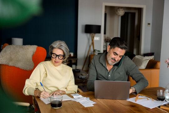 Couple managing finances together, budgeting household expenses