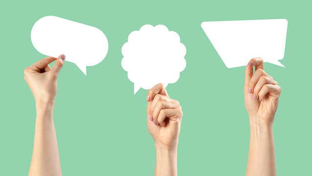 Creative hands holding empty speech bubbles on a light green background for communication ideas