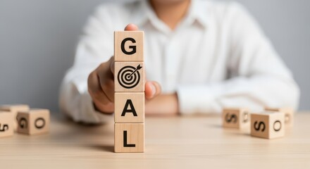 Setting Business Goals and Achieving Success Concept with Hand Stacking Wooden Blocks Labeled 'GOAL' and Target Icon