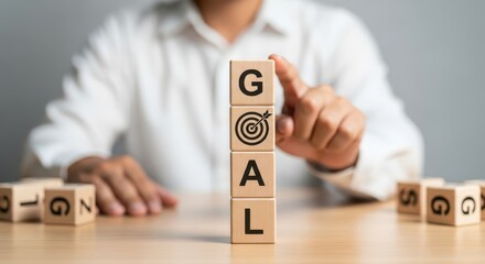 Setting Business Goals and Achieving Success Concept with Hand Stacking Wooden Blocks Labeled 'GOAL' and Target Icon