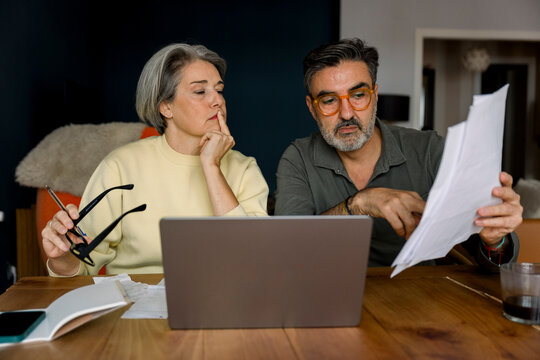 Mature couple analyzing home finances and retirement planning