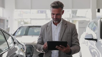 Man customer male buyer client wear classic suit use digital tablet pc computer chooses auto wants to buy new automobile in car showroom vehicle salon dealership store motor show indoor. Sales concept - Powered by Adobe