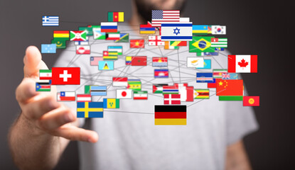 A hand holding a network of connected flags representing global communication, international relations, and unity across countries. World peace