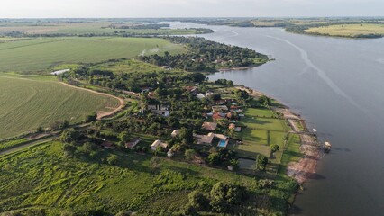Aerial view of a rural landscape with a river and houses near fields © Segati