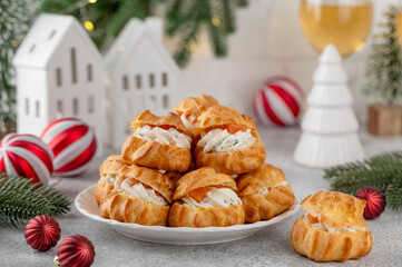 Savory profiteroles with smoked salmon, cream cheese and dill on a plate on a concrete background. Appetizer for Christmas and New Year. Selective focus, copy space.