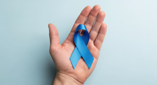 Male hand holding blue awareness ribbon symbolizing health support, medical campaign, solidarity and prevention on pastel background - Powered by Adobe