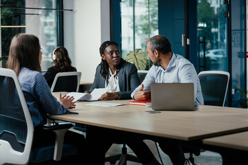 Diverse Business Team Collaborating in Modern Glass Office
