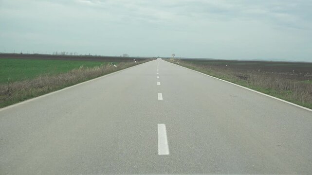 Ahead view low angle car drive on long straight empty road