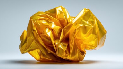 A striking piece of crumpled yellow plastic sits on a minimalist background, showcasing the beauty of everyday materials and challenging perceptions of art.