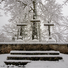 Faith enduring : three crosses covered by silent winter snow.
