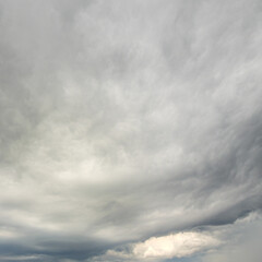 Obraz premium Expansive dramatic overcast sky filled with swirling grey white clouds.