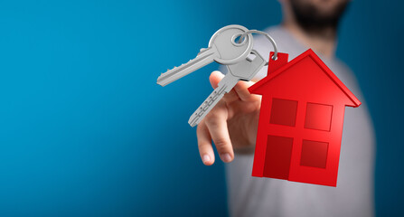 A hand presents keys and a small house model. It symbolizes home ownership, real estate, security, and dream fulfillment. Ideal for housing, mor © vegefox.com