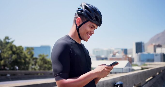 Fitness, typing and cyclist on bridge with phone, message reply or social media scroll on cycling break. Smile, helmet and man outdoor with tech, wellness chat or internet browse in energy recovery.