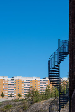 Architecture highlighted by a staircase rising through geometry across a firm exterior structure enhanced by urban metal detail projecting modern symmetry framed by clean minimal design lines