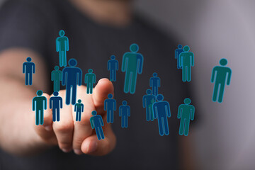 Hand touching digital people symbols, representing teamwork, unity, and global networking. Social connection co