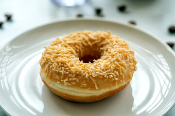 Coconut Topped Donut on White Plate in Soft Natural Light