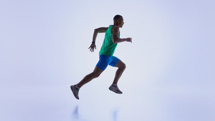 Naklejka premium Runner in suspended forward motion during active sprint. Concept of sports promo materials, biomechanics explainer visuals, athletic progress tracking, and workout program design.