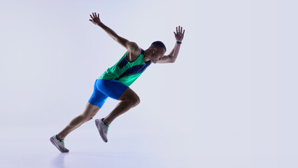 Naklejka premium Runner advancing from crouched start into acceleration phase. Concept of sprint technique guides, athlete development programs, coaching materials, and sports product promotions.