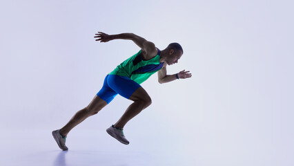 Runner stepping into low start posture before sprint. Concept of athlete preparation tutorials, sprint mechanics lessons, sports education materials, and fitness training resources.