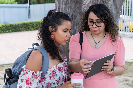 Students discussing project data using digital tablet outdoors