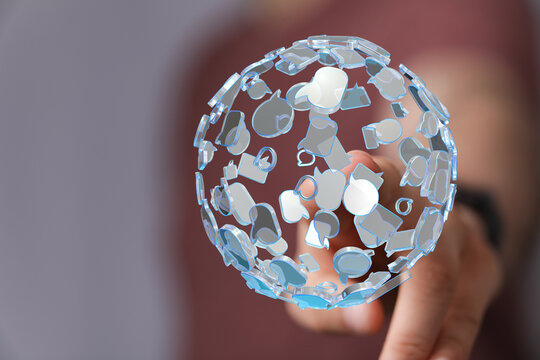 Conceptual image of communication network. A transparent sphere of speech bubbles held by a hand represents global connection and ideas. - Powered by Adobe