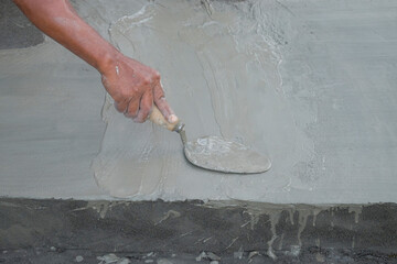 Close up of hands plastering the floor using cement. Copy space for text. For graphic design, 3D...
