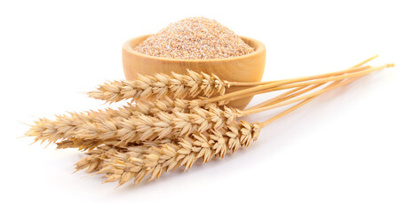 Wheat groats in wooden bowl with dry wheat ears isolated on white