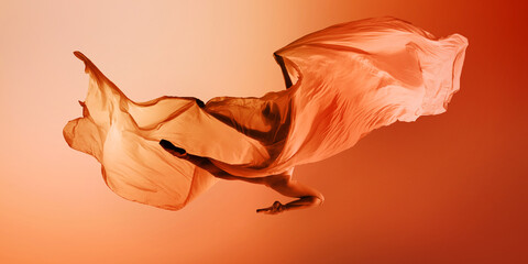 Ballet dancer floating under large orange fabric wave on warm background. Concept of campaign visuals, airy dance moments, editorial movement photography.