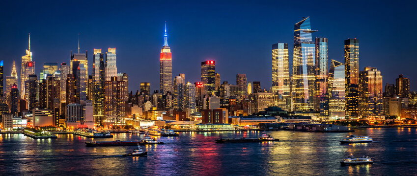 Panoramic view of new york city skyline at night with illuminated buildings and boats on water