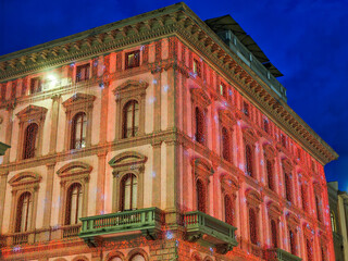 Ancient building in the center of Florence decorated with red Christmas lights