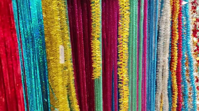 Colorful Christmas Tinsel and Garlands Display in store, holiday shopping background