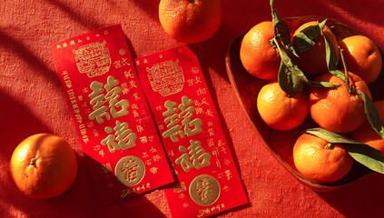 Red envelopes and tangerines symbolize good fortune during chinese new year celebrations