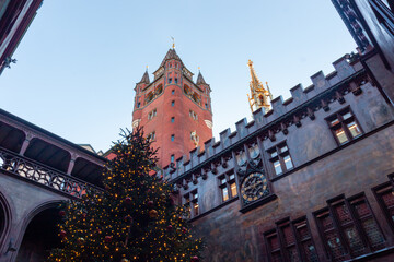 Low angle view of the decorated Christmas tree and the historic red Town Hall (Rathaus) tower with a golden spire