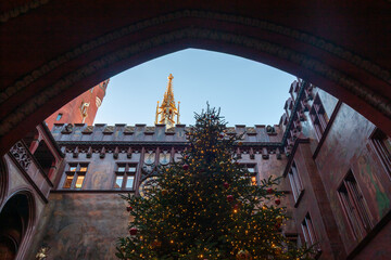 Illuminated Christmas tree framed by a red archway in the historic Town Hall (Rathaus) courtyard...