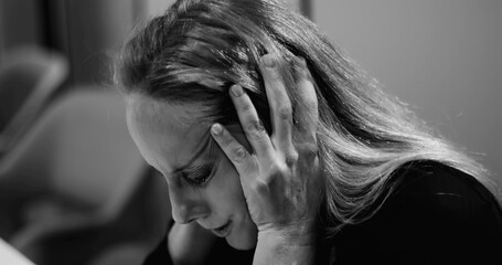 Stressed businesswoman pressing hands to ears in frustration, overwhelmed by workplace demands and...