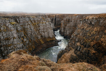 Kolugljúfur Canyon with a waterfall and river surrounded by beautiful rocks,