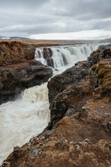 Kolugljúfur Canyon with a waterfall and river surrounded by beautiful rocks,