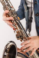 Obraz premium Close up of stylish girl playing saxophone, performing isolated over white background. Jazz performer
