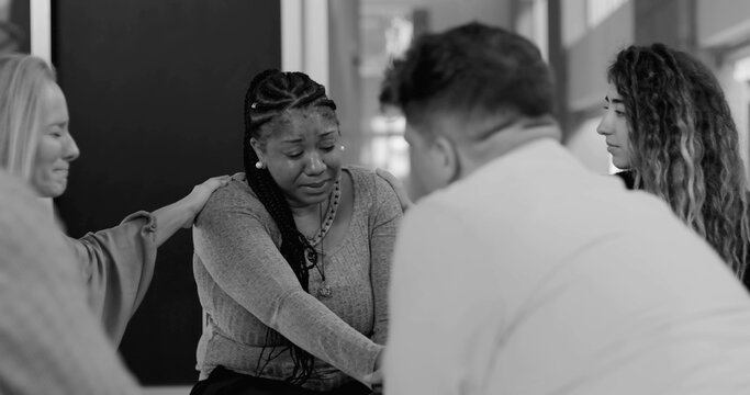 Support group consoling crying woman during intense therapy session, holding hands and offering emotional reassurance in healing circle, black and white - Powered by Adobe