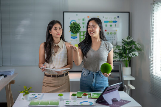 Women presenting sustainability concept with levitating plants in office - Powered by Adobe