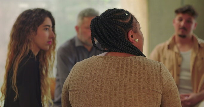 Support group listening attentively as woman shares her story, seated in healing circle during emotional therapy session