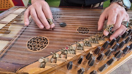 man playing qanun, traditional turkish instrument, kanun, turkish man performing wooden string instrument in Al Ain Zoo Celebration of Independence Day of the UAE.2 December 2025 